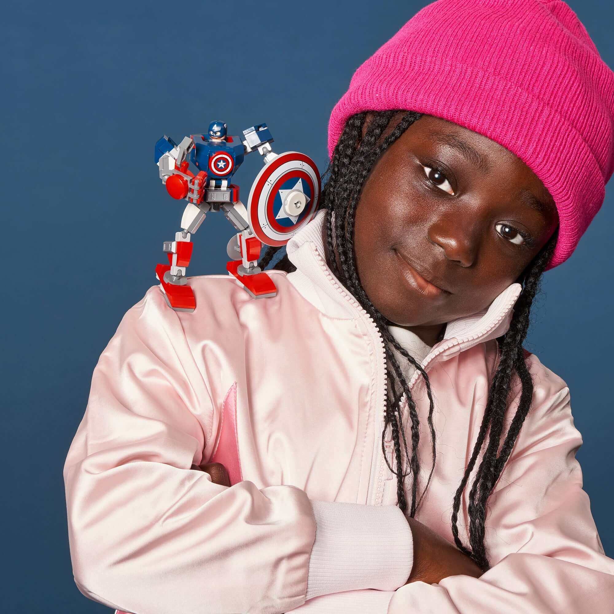 Child with a giant Captain America mech toy on shoulder, showcasing creativity and superhero fun.