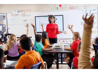 Teacher engaging students in a classroom discussion about math, children raising hands to participate.