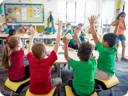 Students engaging and raising hands in a colorful classroom, showcasing interactive learning and gamification.