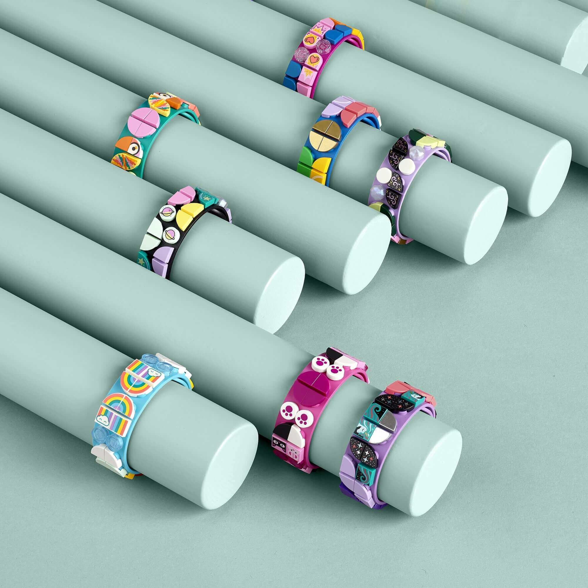 Colorful DOTS Go Team! DIY bracelets displayed on pastel cylinders, perfect for a young sports fan's creative play.