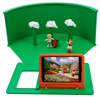 Greenscreenbox for kids role-play, featuring figures, trees, and a tablet displaying creative adventures.