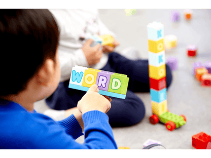 Child playing with LEGO® DUPLO® bricks, spelling the word 'WORD' in colorful letters during learning activities.