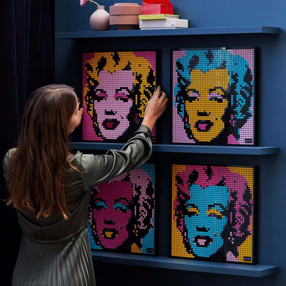 Person assembling LEGO® Art Andy Warhol's Marilyn Monroe wall art set, showcasing vibrant colors and unique design.