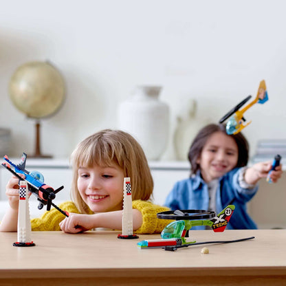 Kids playing with LEGO® City Airport Air Race set, featuring toy helicopters and stunt planes for imaginative fun.