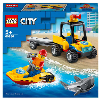 LEGO® City 60286 Beach Rescue ATV with trailer, water scooter, lifeguard minifigure, and shark toy on sandy beach.