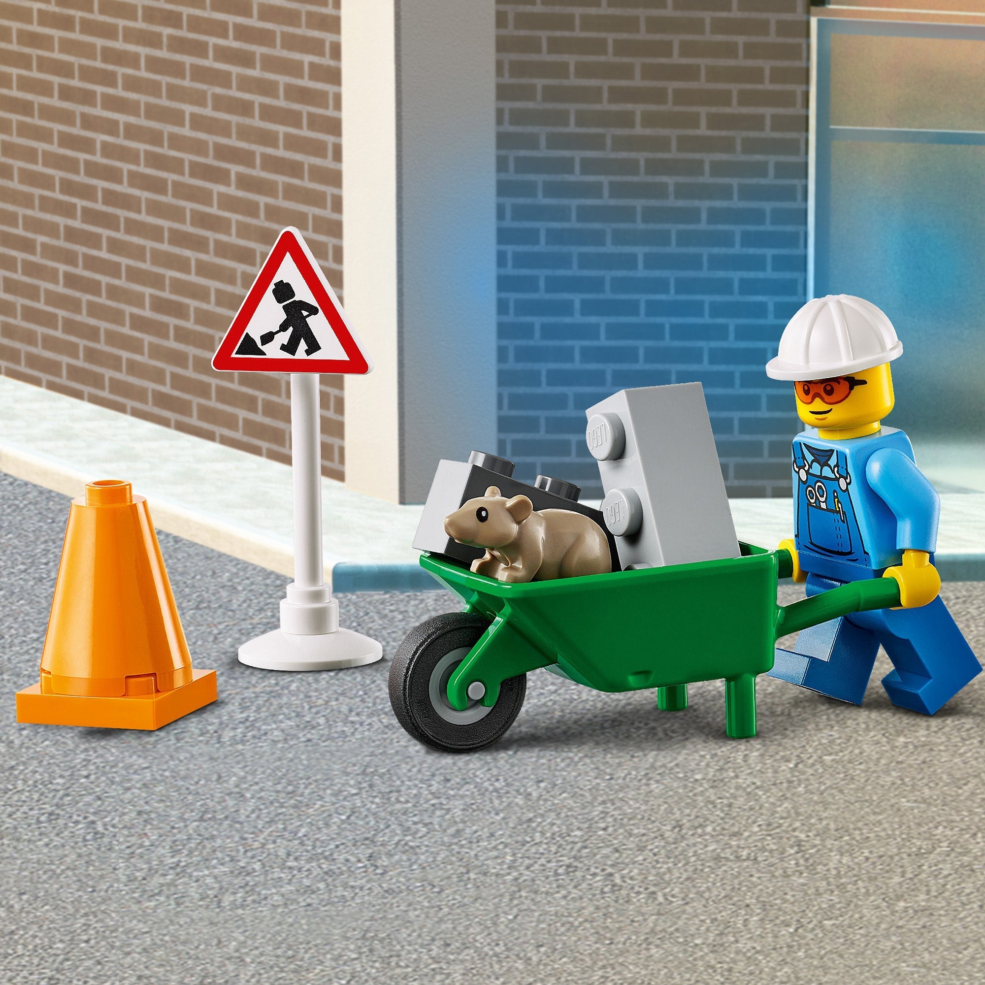 LEGO City roadwork scene with a construction worker pushing a wheelbarrow, traffic cones, and a caution sign.