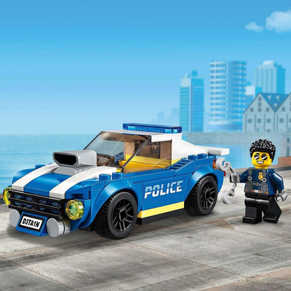 LEGO® City Police Highway Arrest Set 60242 with Duke DeTain and police car in a cityscape.
