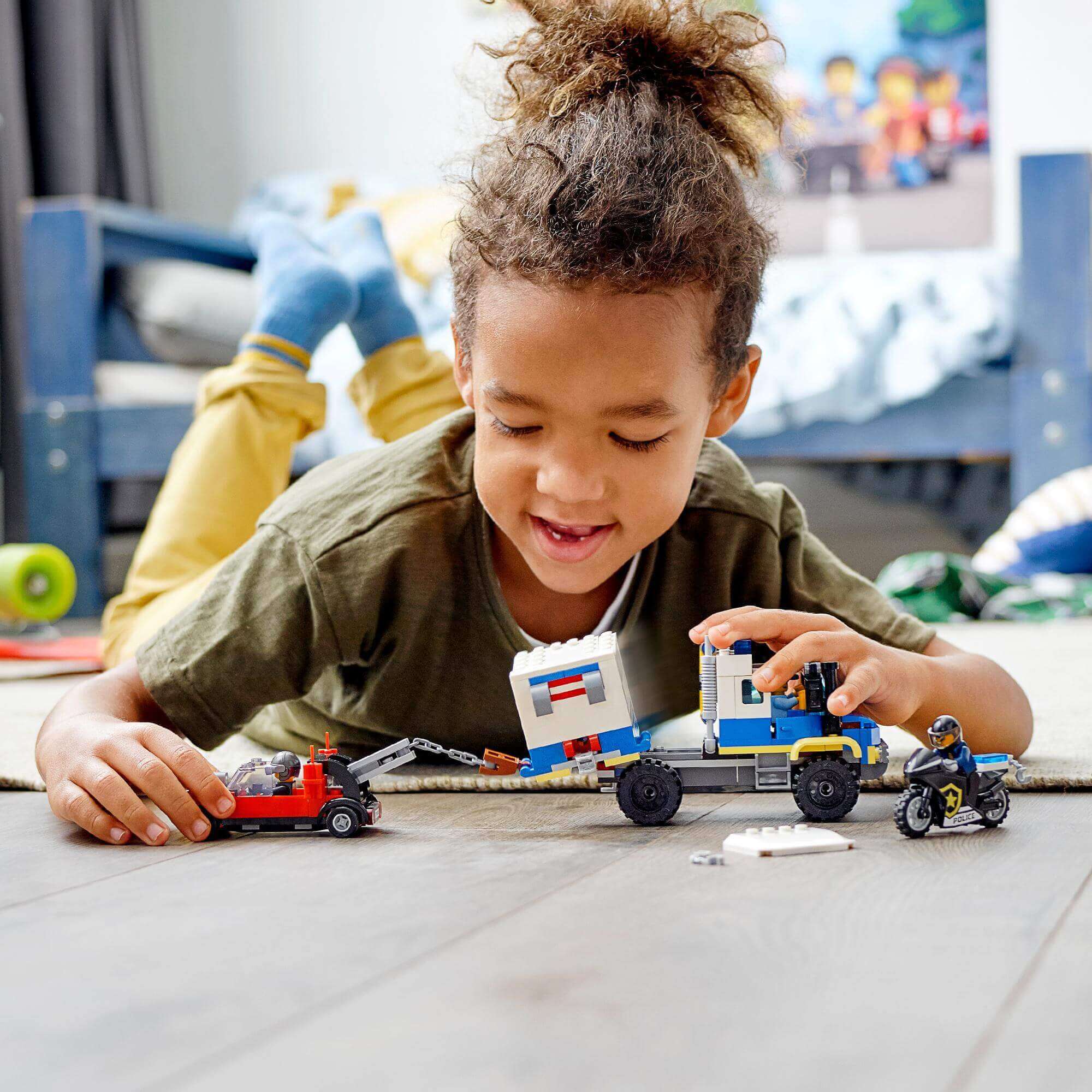 Child playing with LEGO® City Police Prisoner Transport Truck Toy 60276, featuring police vehicle and mini-figures