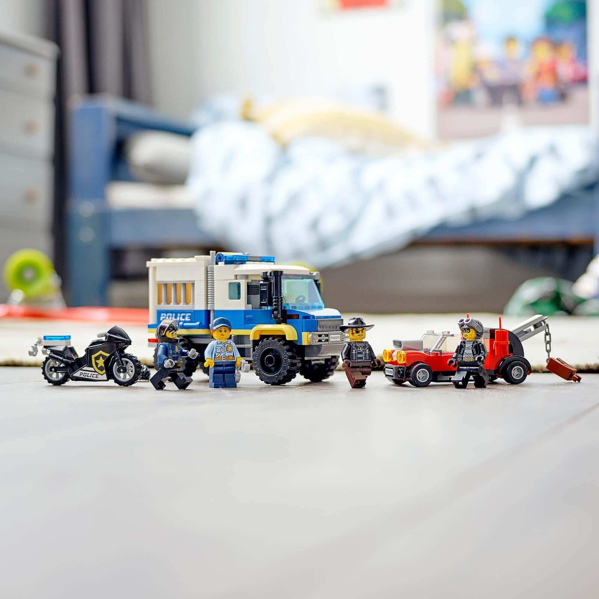 LEGO® City Police Prisoner Transport Truck 60276 with police vehicle, motorcycle, and minifigures in a colorful playroom.
