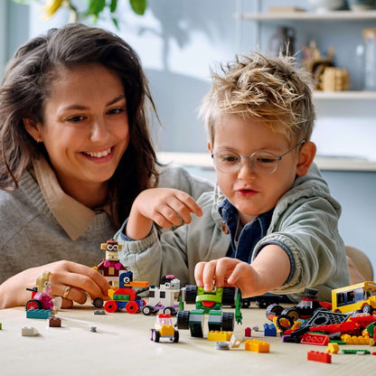 A mother and son enjoying creative play with LEGO® Classic Bricks and Wheels Building Set 11014, showcasing colorful bricks and wheels.