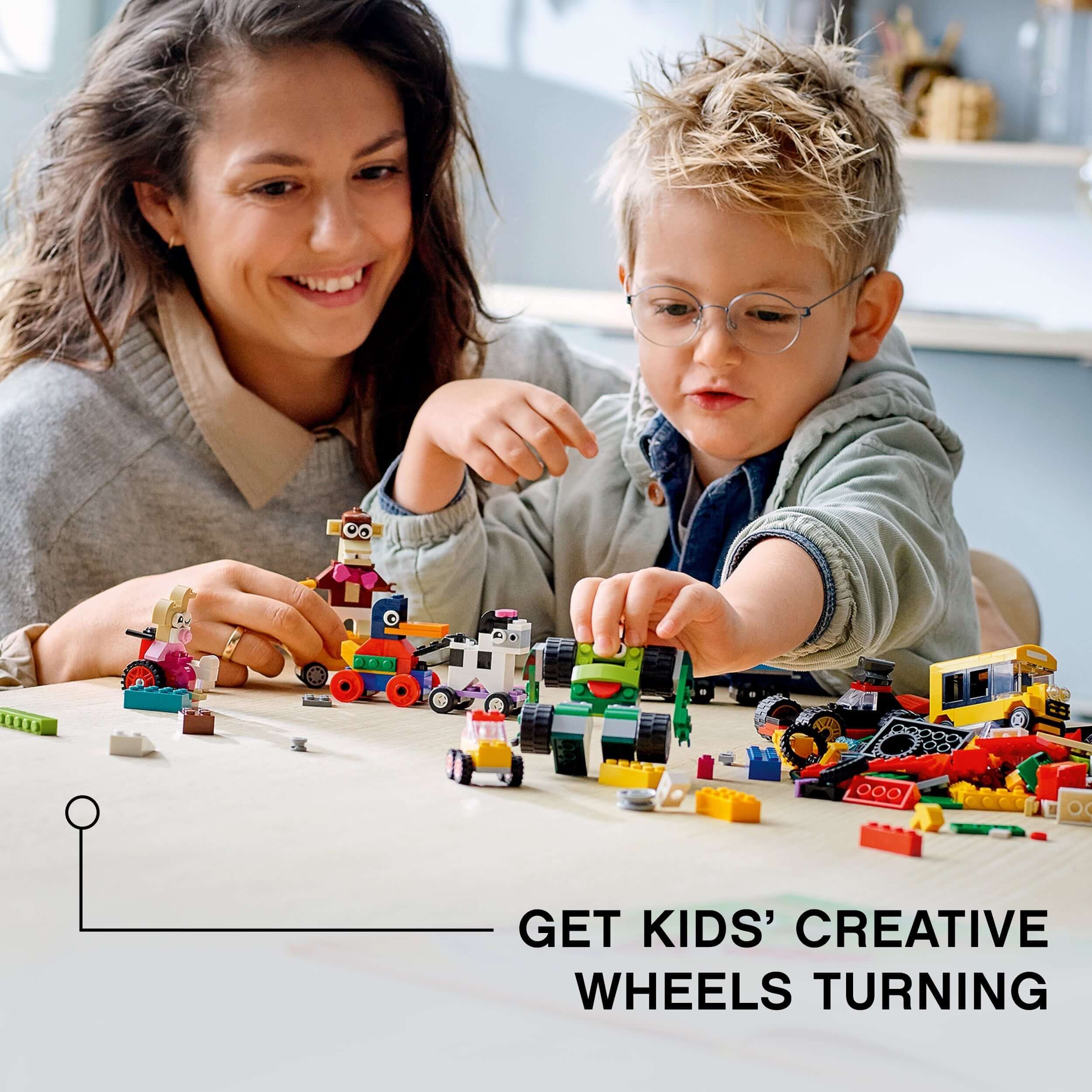 Mom and child building with LEGO® Classic Bricks and Wheels set 11014, sparking creativity and imagination.