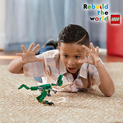 Excited child playing with LEGO® Creator 3in1 Mighty Dinosaurs T-Rex model, showcasing creativity and fun.