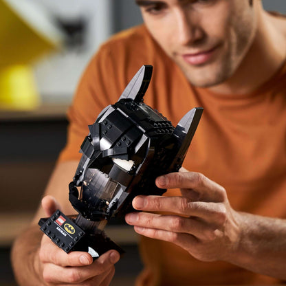 Adult man assembling the LEGO® DC Batman Cowl Set 76182, showcasing his passion for building and Batman.