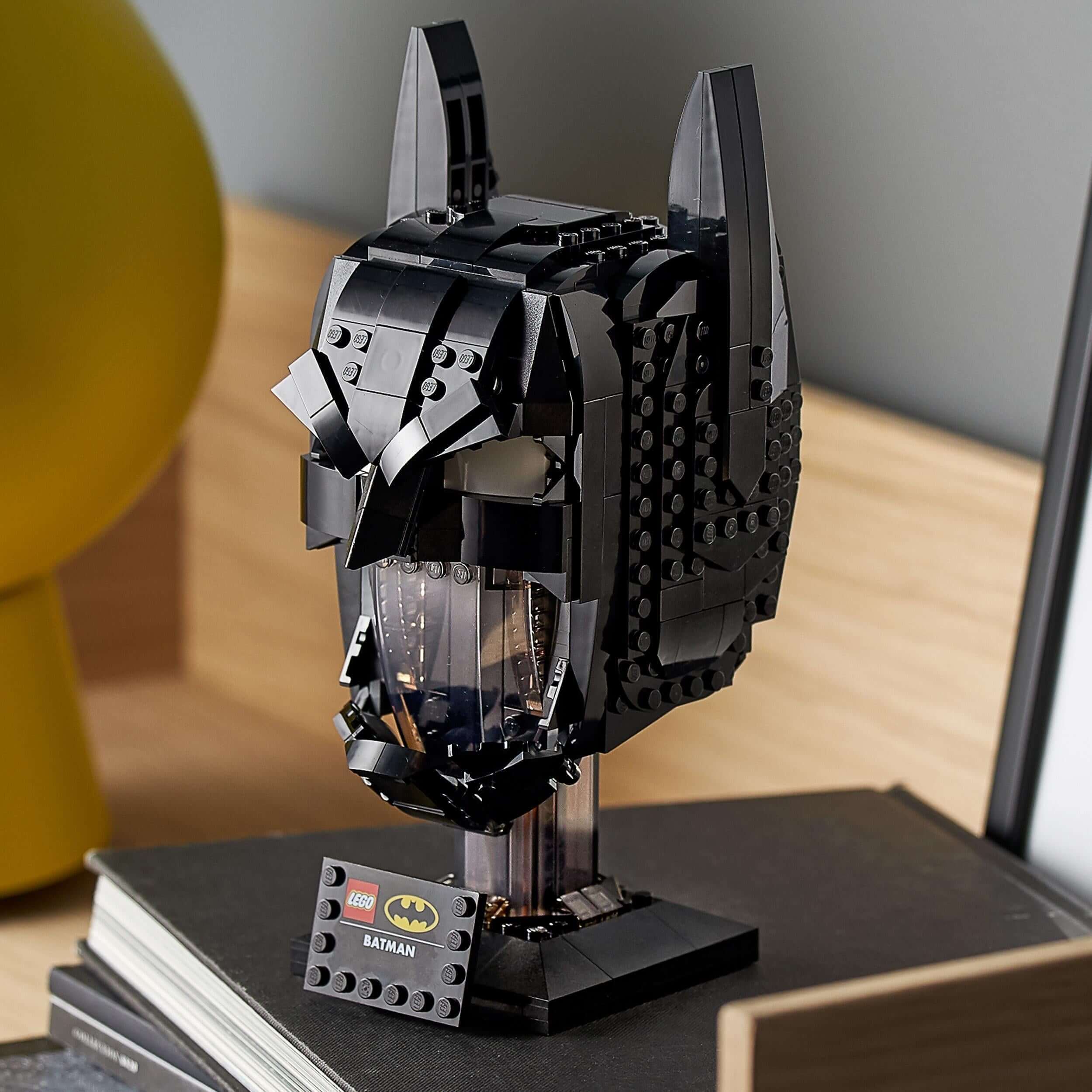 LEGO® DC Batman Cowl Set for Adults 76182, showcasing a detailed black Bat cowl model on a desk.