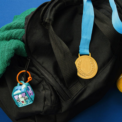LEGO® DOTS Narwhal bag tag attached to a black backpack, showcasing customizable accessories for kids.