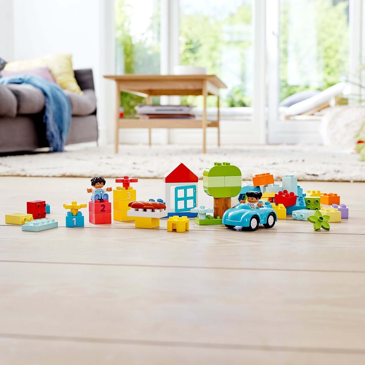 Colorful LEGO® DUPLO Classic Brick Box Set 10913, featuring toddlers playing with building blocks, a car, and a vibrant play area.