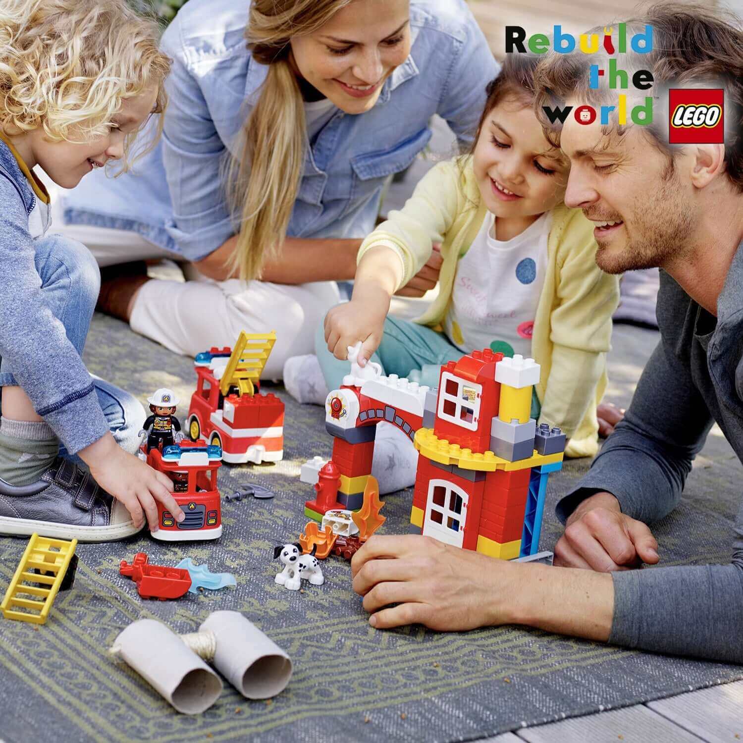 Family enjoying LEGO DUPLO Town Fire Station set 10903, building fire station with light and sound features.