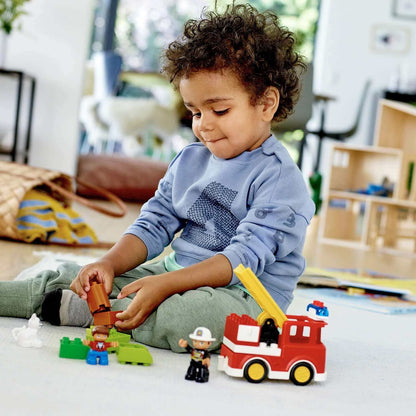 Child playing with LEGO® DUPLO Town Fire Truck set, engaging in creative building fun.