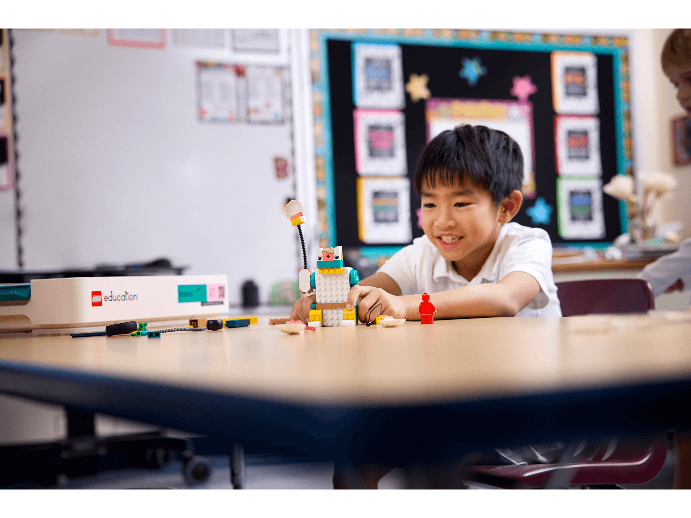 Young boy engaged with LEGO® Education Science kit, building and exploring in a classroom setting.