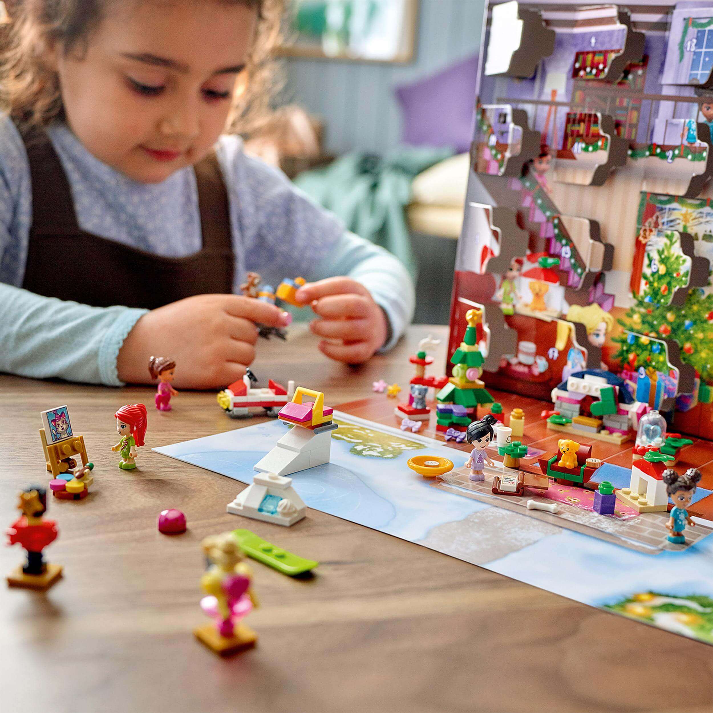 Child playing with LEGO Friends Advent Calendar, featuring characters and festive decorations for a joyful Christmas countdown.