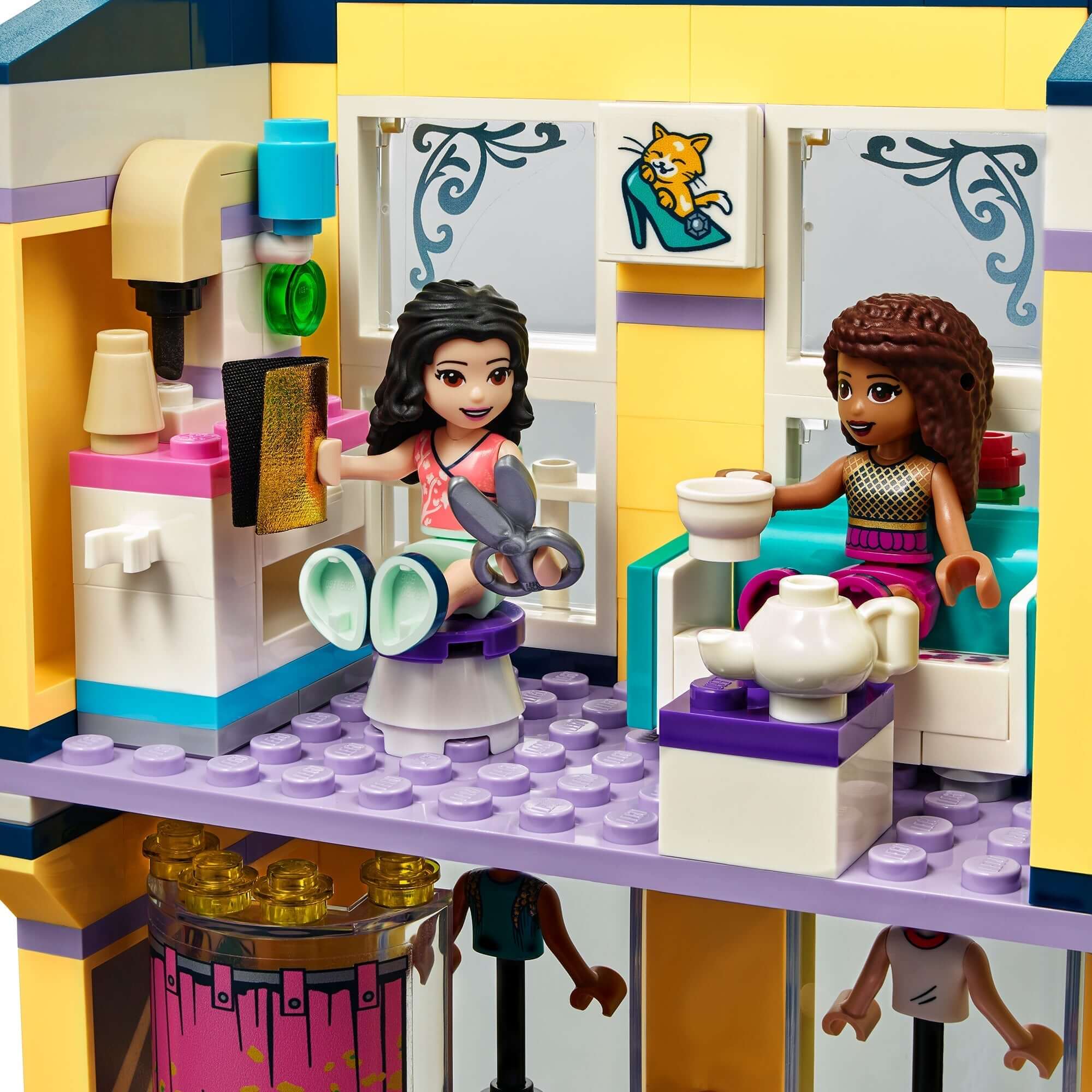 LEGO® Friends Emma's Fashion Shop playset showcasing two mini-dolls enjoying a cozy moment in a stylish boutique.