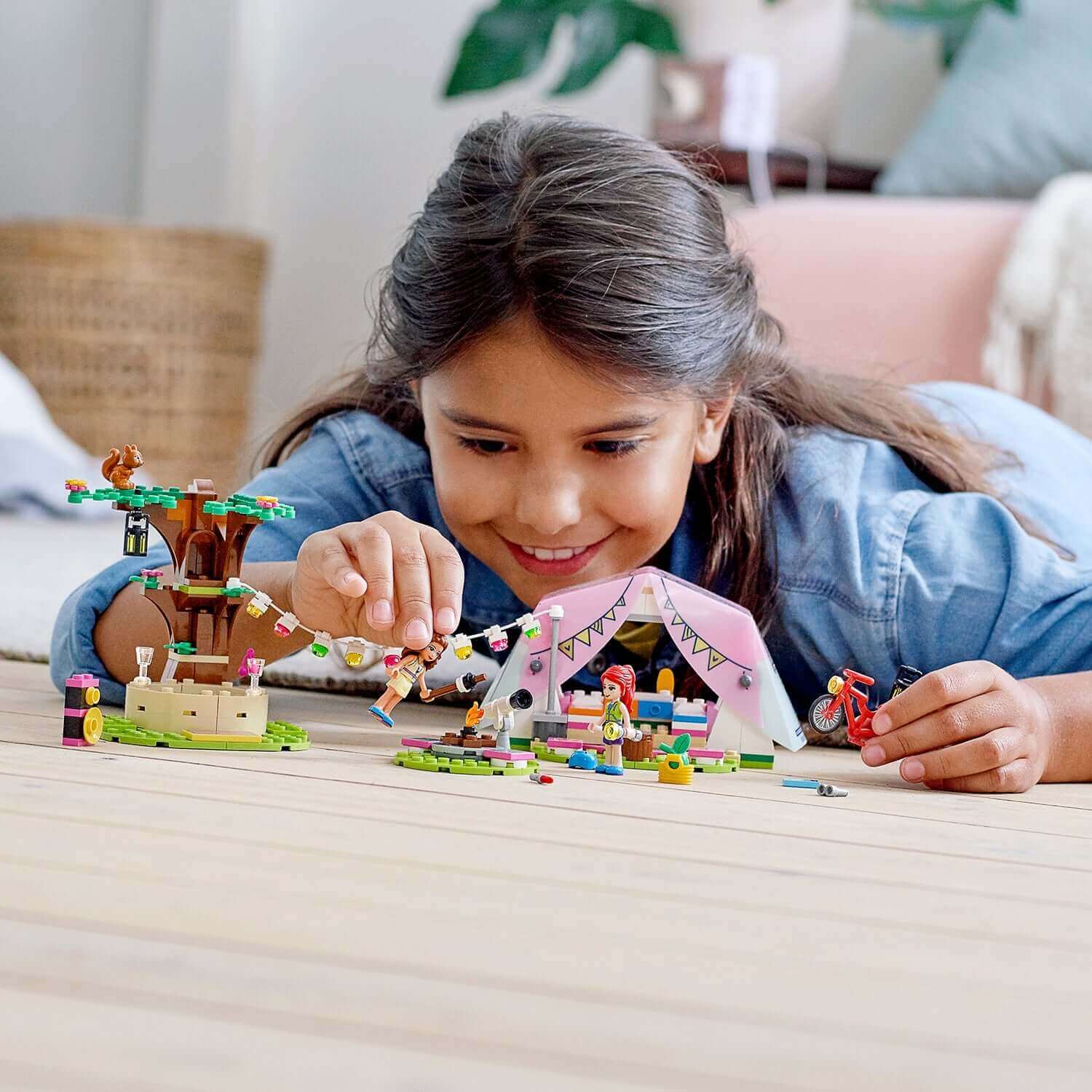 Child playing with LEGO® Friends Nature Glamping Camping Set 41392, exploring nature and enjoying fun outdoor adventures.