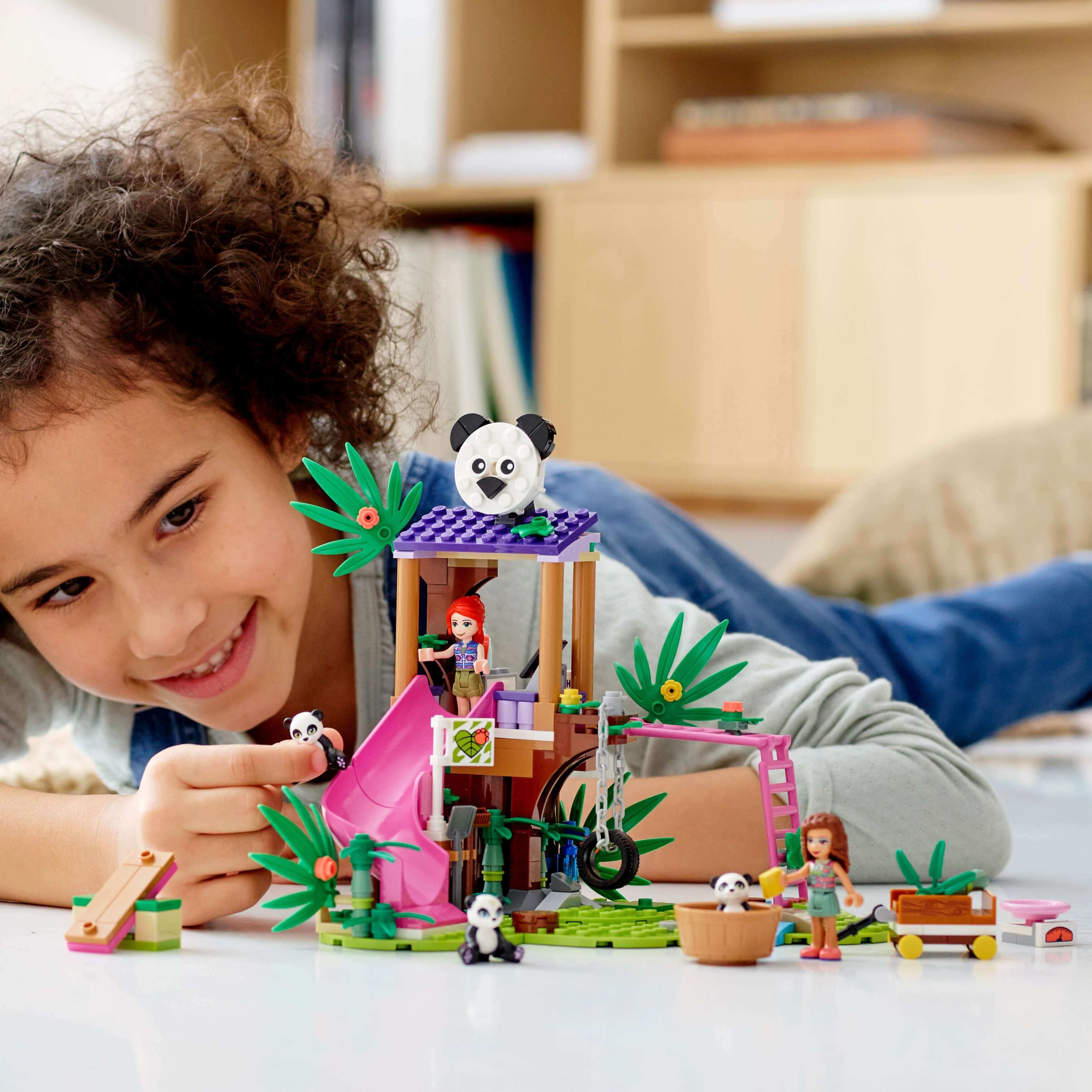 Child playing with LEGO® Friends Panda Jungle Tree House Toy 41422, exploring wildlife and adventure.