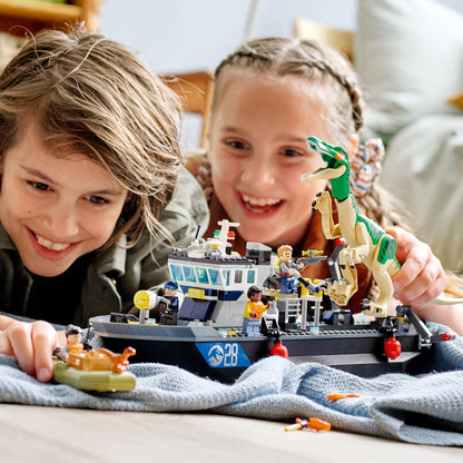 Kids play with LEGO® Jurassic World Baryonyx Boat set; creative fun with dinosaur and boat toy figures.