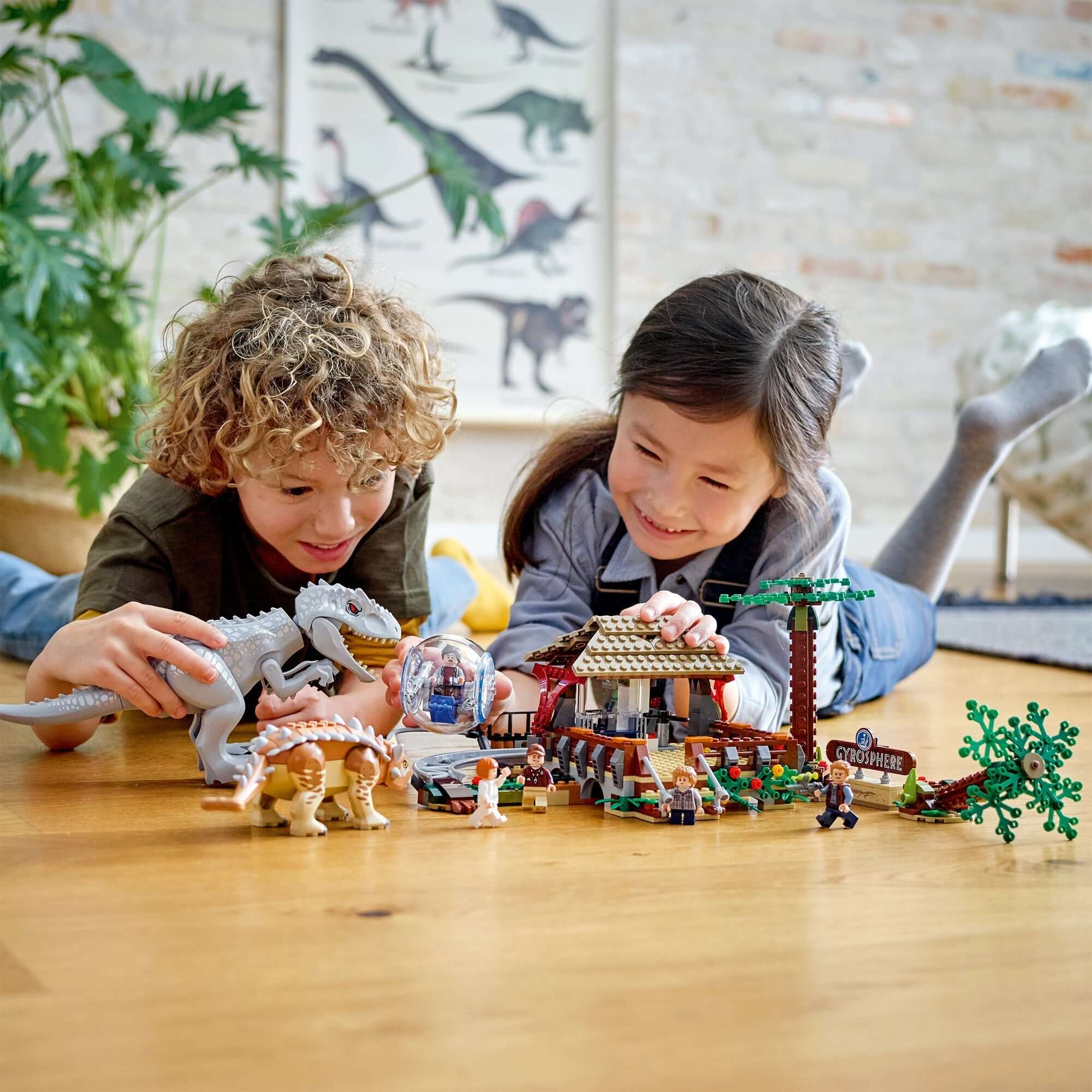 Children playing with LEGO® Jurassic World Indominus Rex dinosaur toy set, showcasing fun dinosaur battles on the floor.