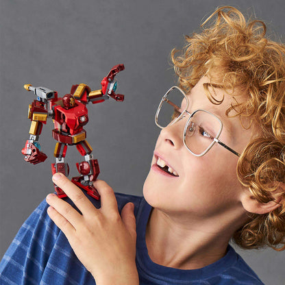 Child joyfully holding LEGO Iron Man mech playset with movable limbs and stud shooter in a playful pose.
