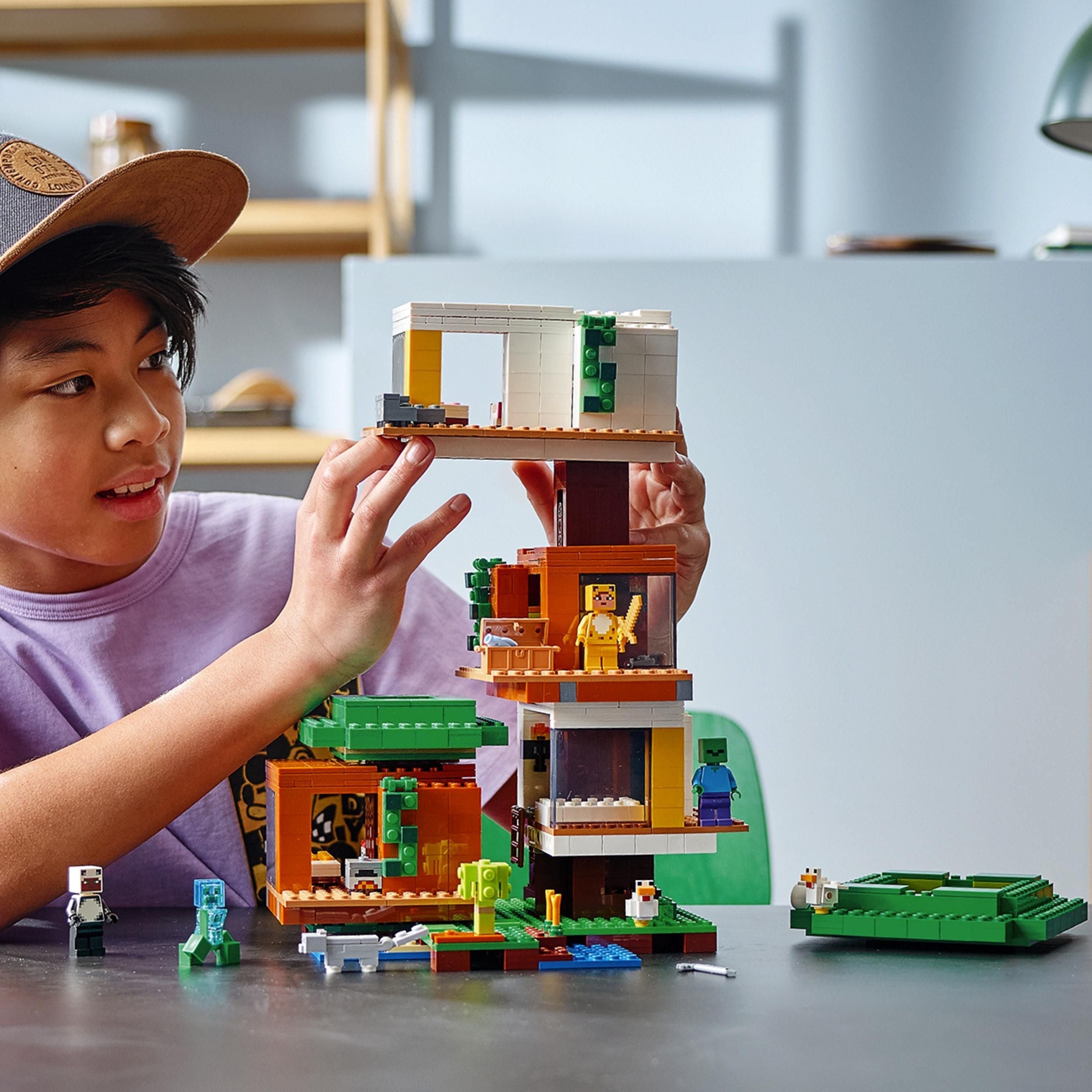 Child building LEGO Minecraft Modern Treehouse 21174 with modular rooms and Minecraft characters in a colorful setting.