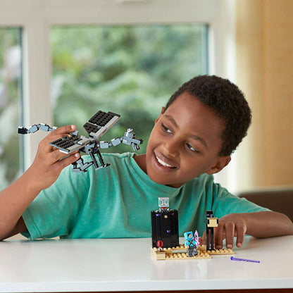 Child enjoying LEGO® Minecraft The End Battle set 21151, featuring a dragon and adventure scene.