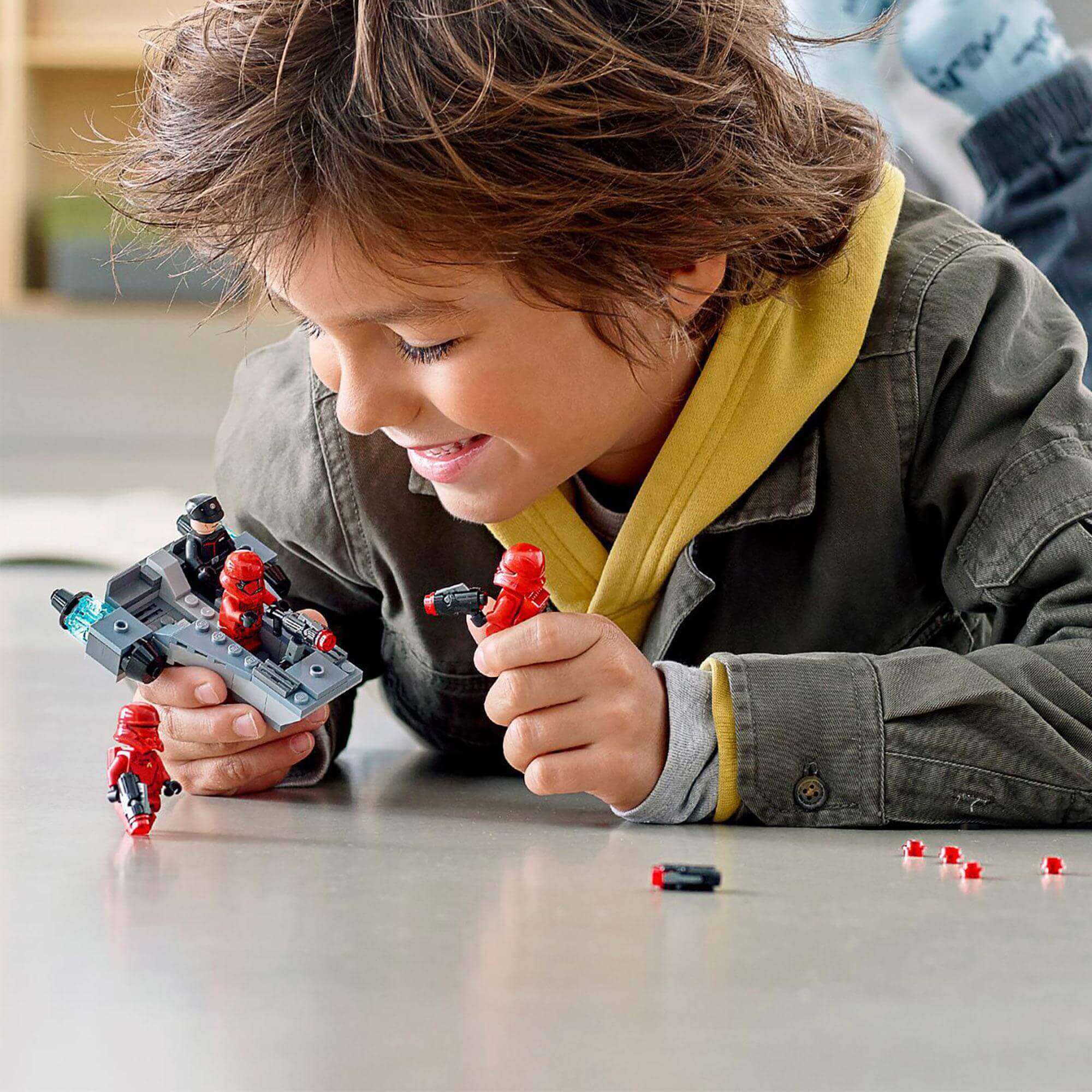 Child playing with LEGO® Star Wars Sith Troopers Battle Pack, building an army of First Order troopers.