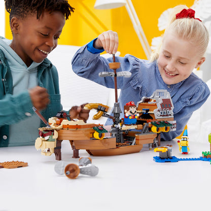 Two kids playing with LEGO® Super Mario Bowser Airship Expansion Set 71391, building and having fun together.
