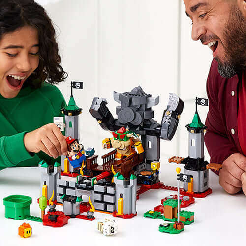 Child and adult enjoying LEGO® Super Mario™ Bowser's Castle Boss Battle Expansion 71369 together.