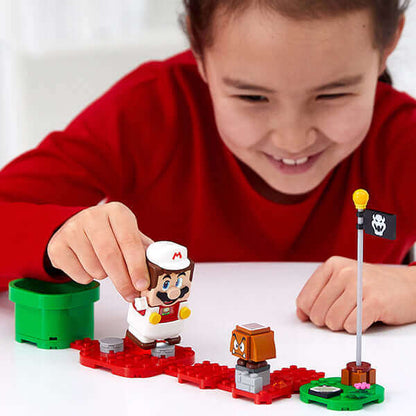 Child playing with LEGO® Super Mario™ Fire Mario Power-Up Pack, interacting with LEGO® Mario™ and Goomba.