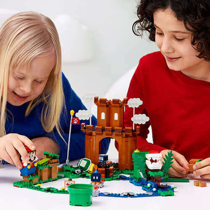 Kids playing with LEGO® Super Mario™ Guarded Fortress Set 71362, featuring a fortress, characters, and interactive elements.