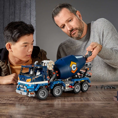 Adult and child build LEGO Technic Concrete Mixer Truck 42112, learning how it operates with realistic features.