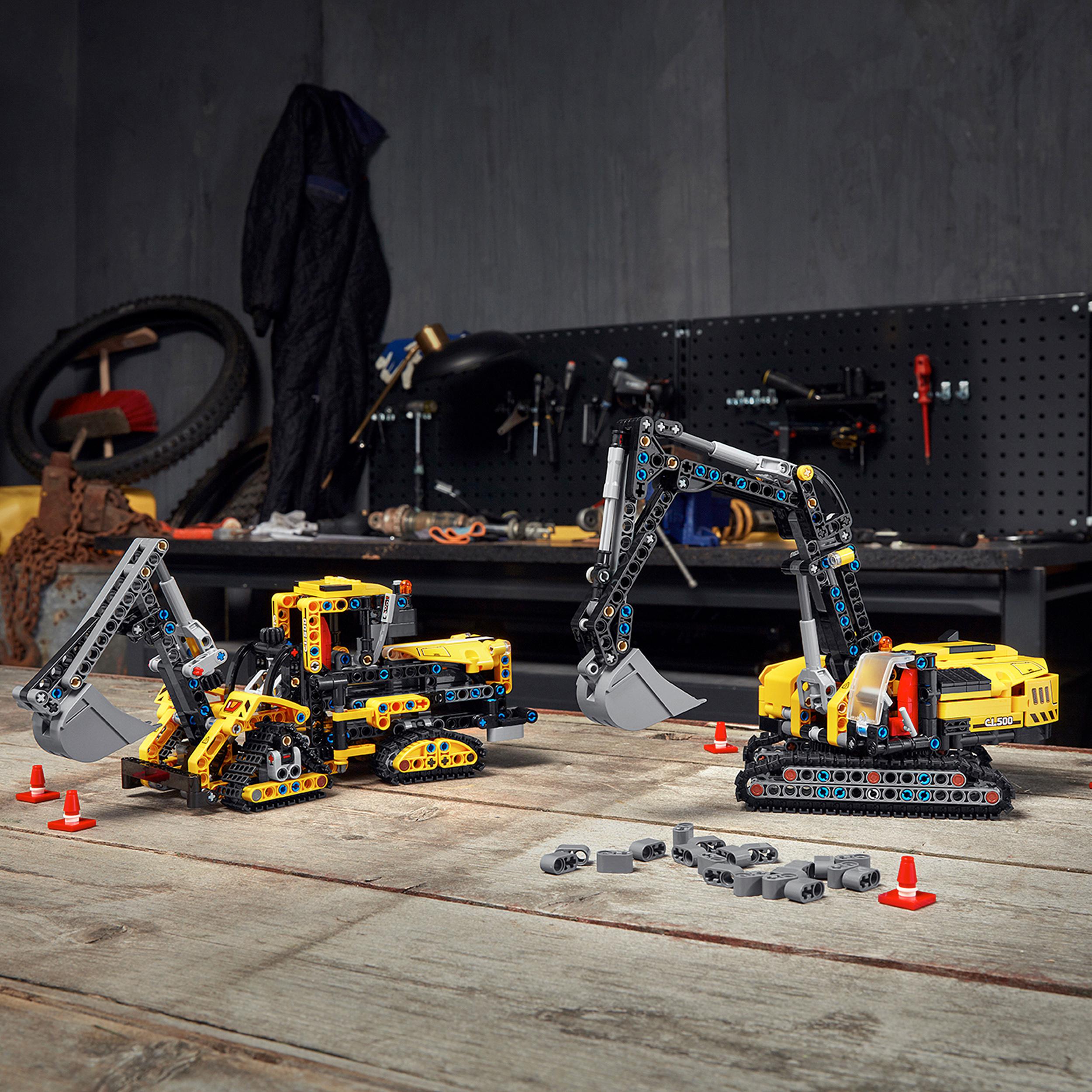 LEGO Technic Heavy-Duty Excavator and crawler model on a workshop table, perfect for construction vehicle enthusiasts.