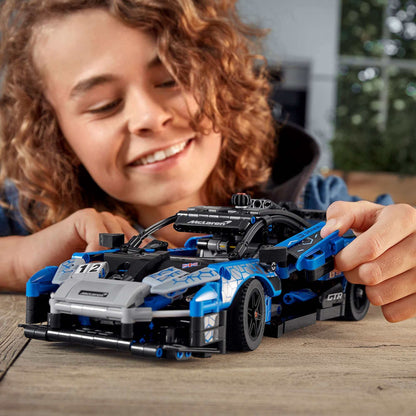 Child engaging with LEGO® Technic McLaren Senna GTR toy sports car 42123, showcasing creativity and joy.