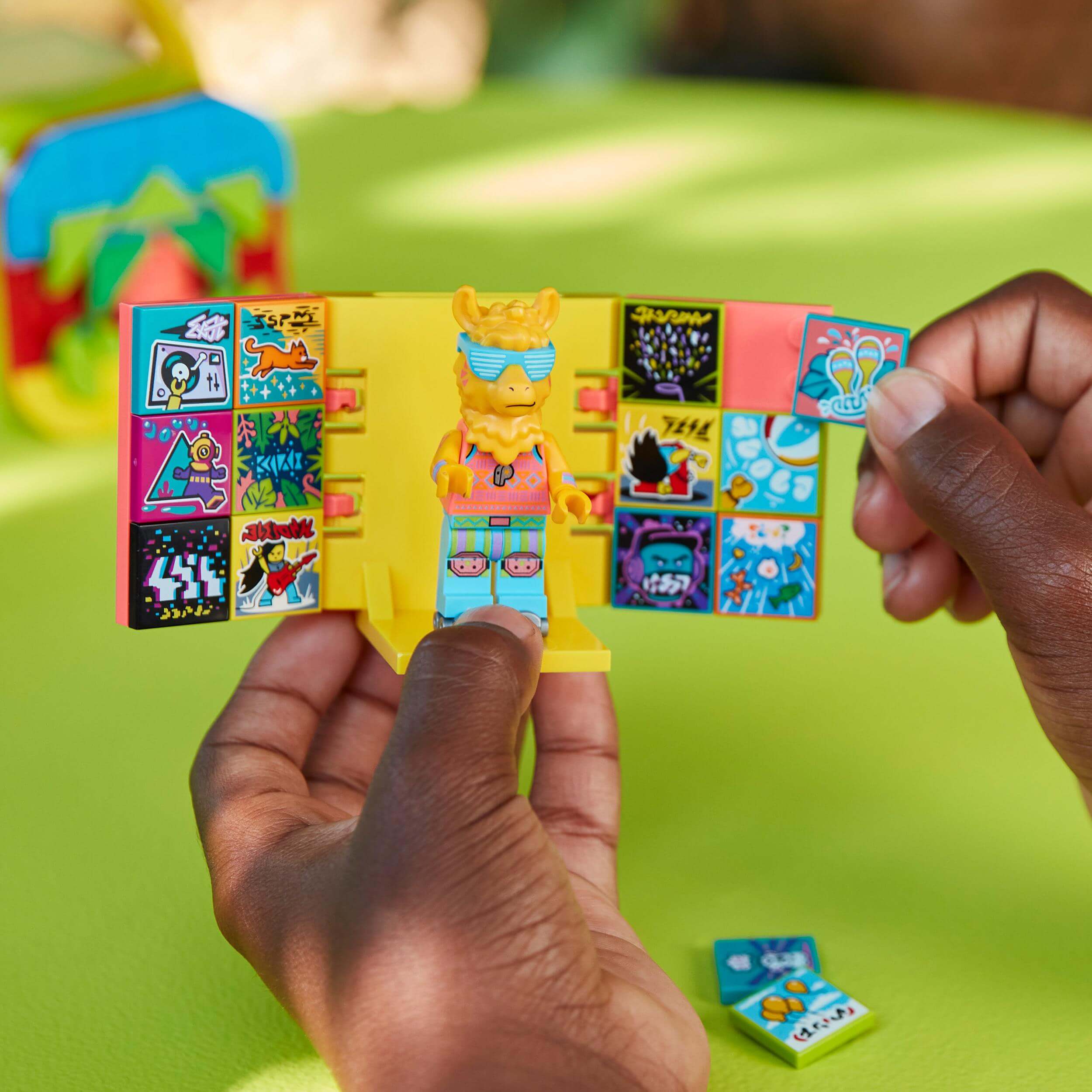 Child holding LEGO VIDIYO Party Llama BeatBox with colorful stickers, inspiring creativity in music videos.