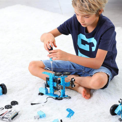 Child assembling Makeblock mBot Ranger robot kit on a soft surface, promoting hands-on STEM learning.