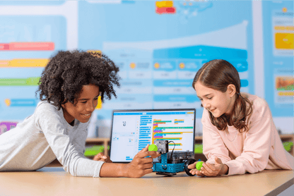 Two students engaging with the Makeblock mBot 2 educational robot, showcasing programming and STEM learning.