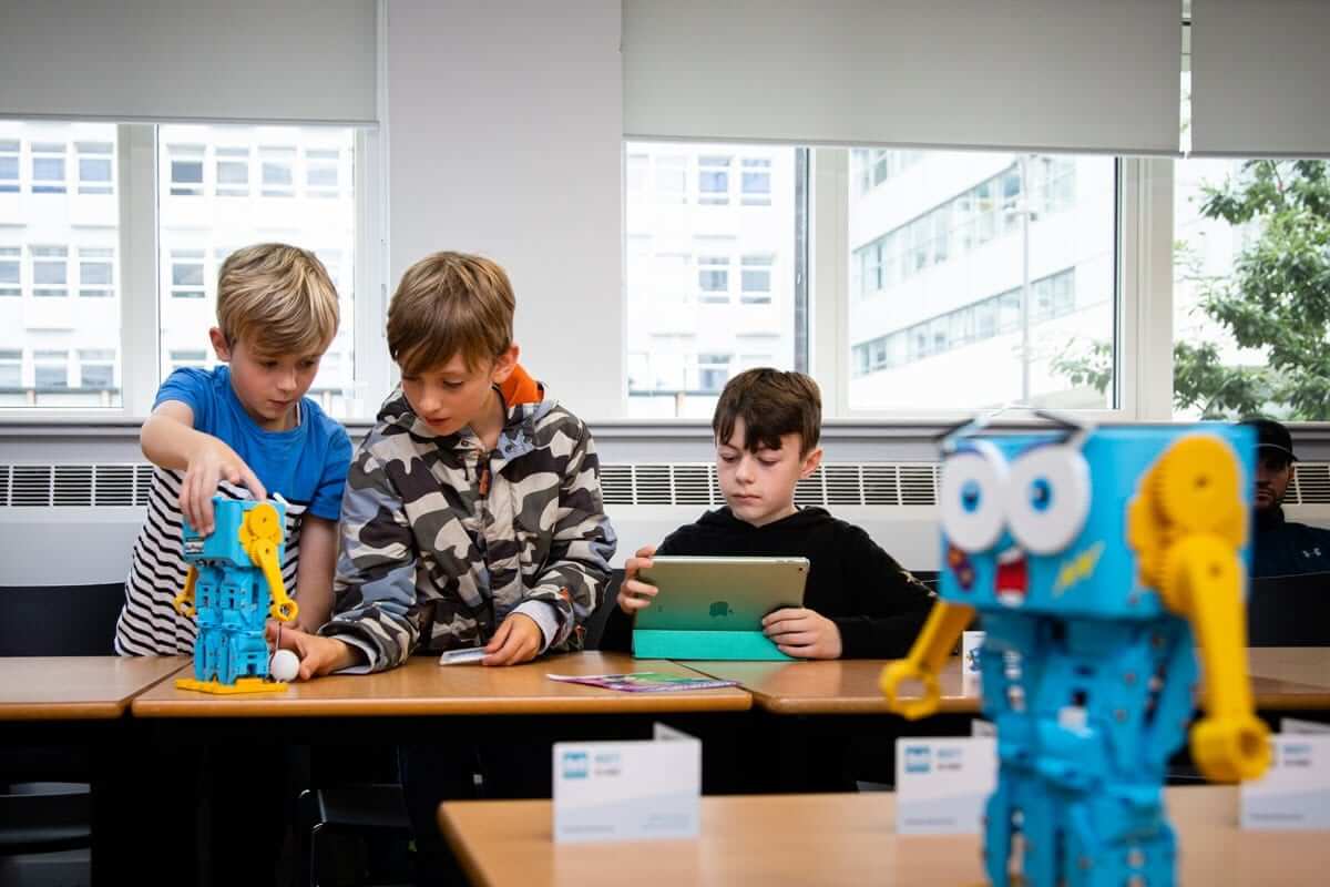 Children engaging with Marty V2 robots in a classroom setting, promoting STEM learning and robotics.
