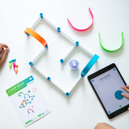 Child interacting with Sphero Mini Activity Kit maze, tablet displaying joystick controls, colorful construction pieces.