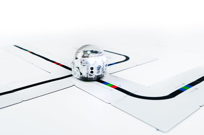 Ozobot Evo robot navigating Color Code Magnets puzzle pieces for interactive coding education.