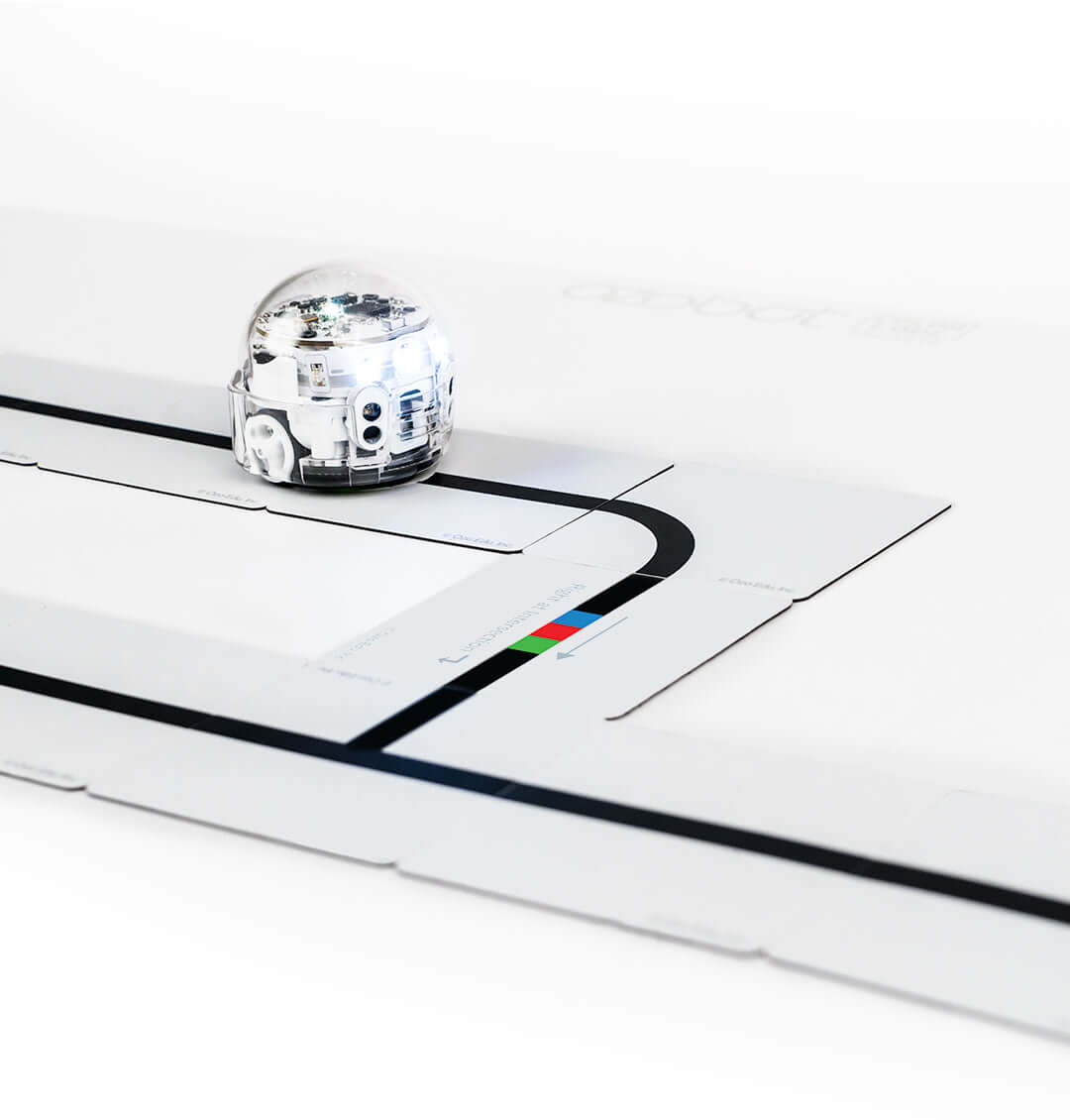 Ozobot Color Code Magnets Base Kit with Evo robot on magnetic board teaching coding basics to students.