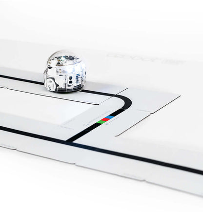 Ozobot Color Code Magnets Base Kit with Evo robot on magnetic board teaching coding basics to students.