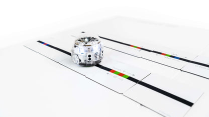 Ozobot Evo robot on Color Code Magnets Speed Kit puzzle pieces for interactive coding education.