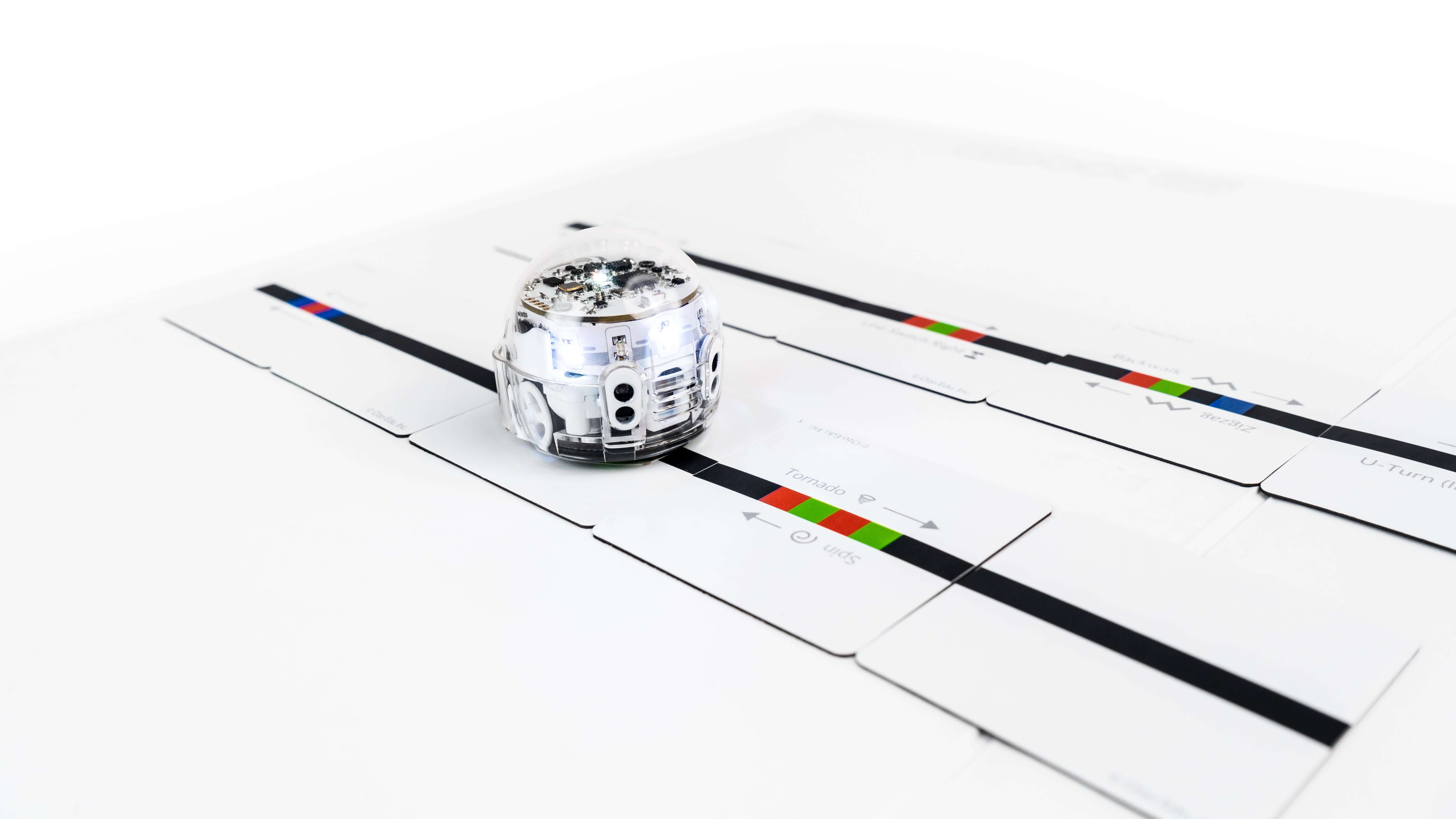 Ozobot Evo robot on Color Code Magnets Speed Kit puzzle pieces for interactive coding education.